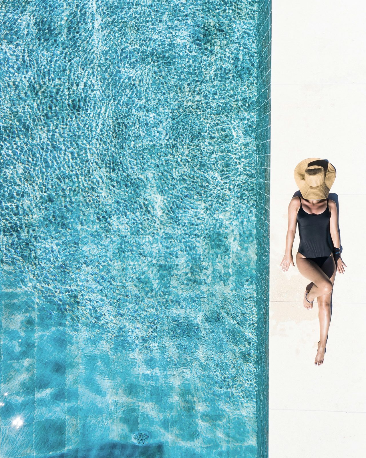 Woman relaxing in a poolside straw hat